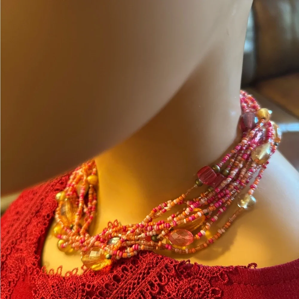 Multi strand torsade style necklace w/coral,pink and salmon colored seed beads